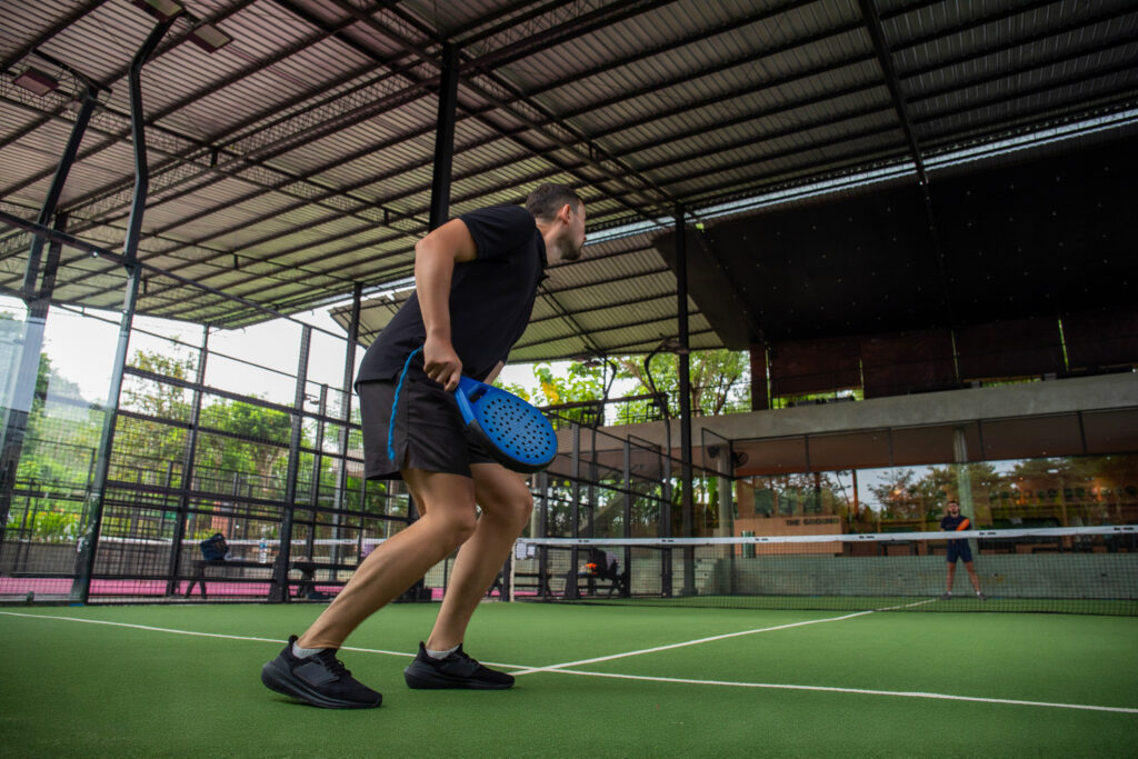 Player prepares for a shot on a green padel court